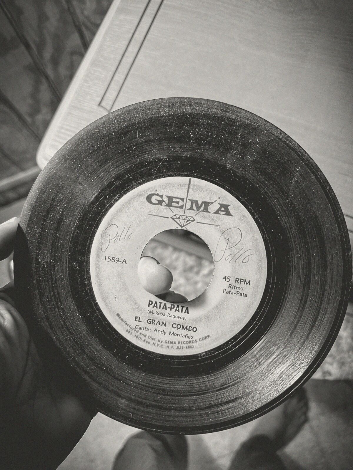 A hand holding a worn 45 rpm record.